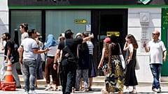 عنصر من الشرطة التونسية يطالب سياحا بالابتعاد عن أحد مكان التفجيرين 