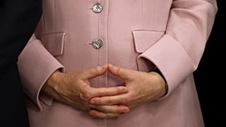 المستشارة الألمانية أنجيلا ميركل تمسك بيديها خلال مؤتمر صحفي في قمة مجموعة العشرين في أوساكا باليابان