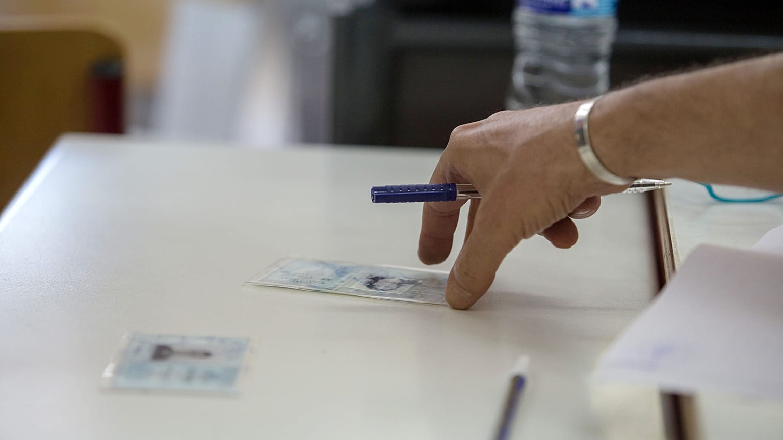 Μέλος εφορευτικής επιτροπής παραδίδει στους πολίτες τις ταυτότητές τους