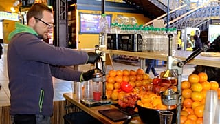 Narancsból, grapefruitból és gránátalmából préselt üdítőitalokat árul egy férfi a Fővám téri Vásárcsarnokban.