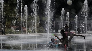 FILE PHOTO: People cool off in a fountain in Nice as a heatwave hits much of the country, France