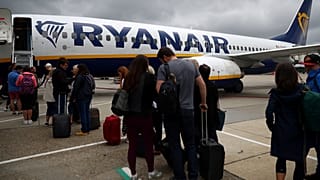 FILE PHOTO: Passengers wait to board a Ryanair flight at Gatwick Airport in London, Britain