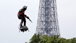 Franky Zapata flies on a Flyboard near the Eiffel Tower during the traditional Bastille Day military parade on the Champs-Elysees Avenue in Paris