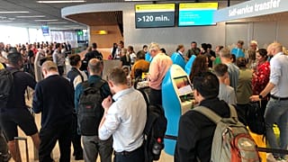 Passengers and staff wait at Amsterdam Schiphol airport during an outage at the airport's main fuel supplier that kept dozens of flights on the ground,