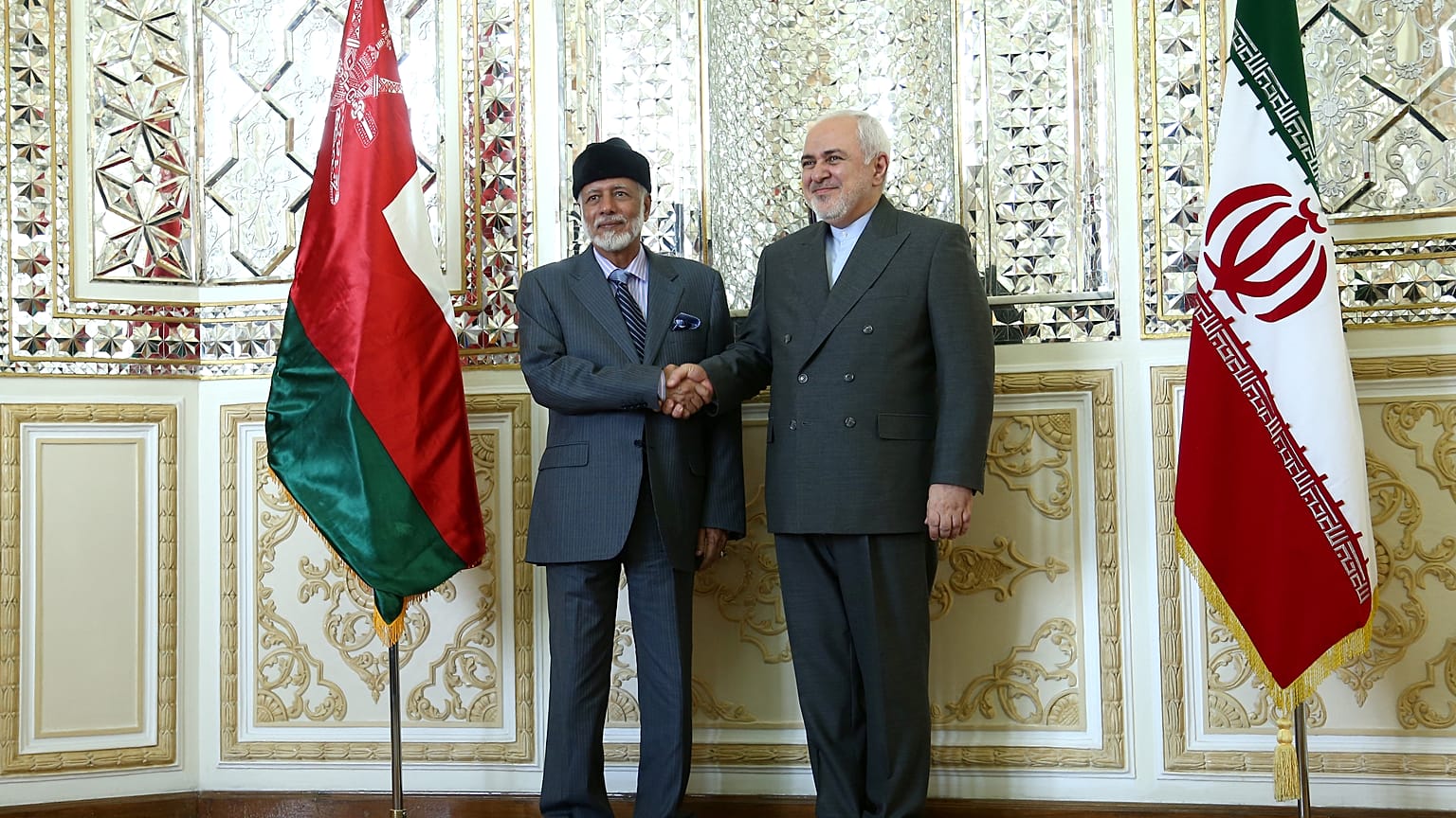 وزير الخارجية الإيراني محمد جواد ظريف (يمينا) يصافح الوزير العماني المسؤول عن الشؤون الخارجية يوسف بن علوي بن عبد الله في طهران يوم السبت