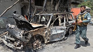 أحد أفراد الأمن الأفغاني يسير في مكان الهجوم الذي ضرب العاصمة كابول يوم 29/تموز/2019