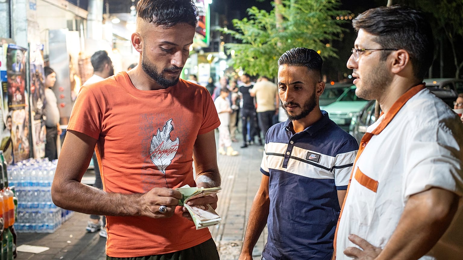 رجل عراقي يحسب المال على الرصيف في حي دولتاباد في طهران، إيران 19 تموز/يوليو 2019