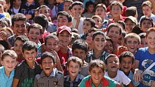 Bir programda gülümseyen Suriyeli çocuklar