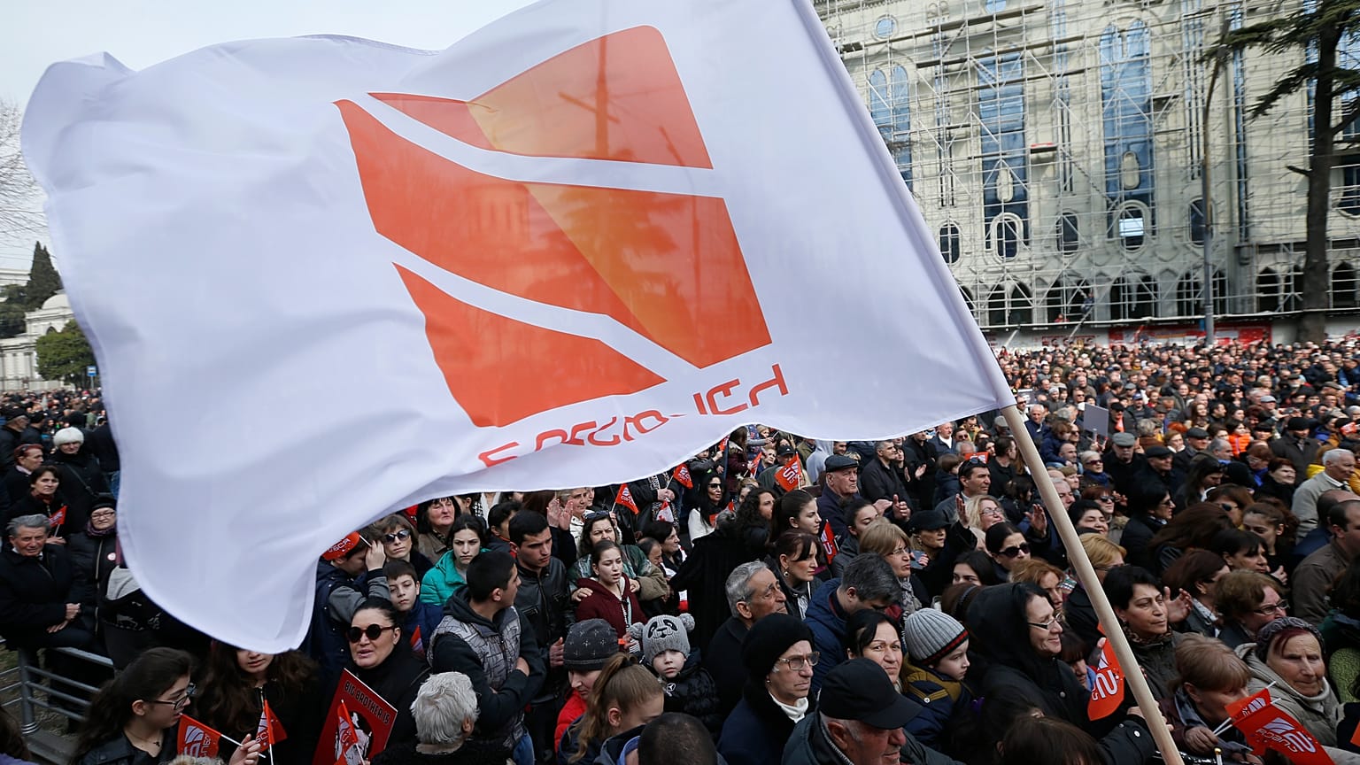 People hold flags with logo of Rustavi 2, Georgia's biggest independent television station, during rally..