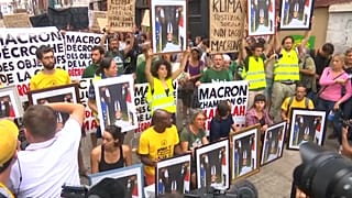 Protesters march in Bayonne carrying stolen portraits of Macron