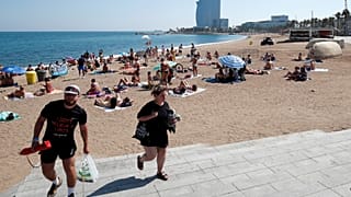 Die Leute verlassen den Strand von Sant Sebastia, nachdem die Polizei einen Sprengsatz im Wasser gefunden und einen Teil davon evakuiert hat