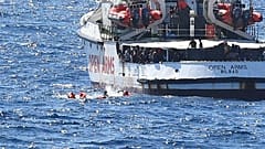 igrants jump off the Spanish rescue ship Open Arms, close to the Italian shore in Lampedusa