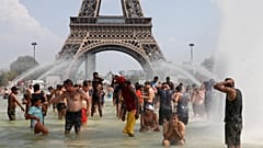 eople cool off in the Trocadero fountains across from the Eiffel Tower in Paris as a new heatwave broke temperature records in France, July 25, 2019.