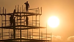 Workers are seen in silhouette, along with the Eiffel Tower, as they construct scaffolding on the Place de la Concorde as the sun sets on an autumn day in Paris, France