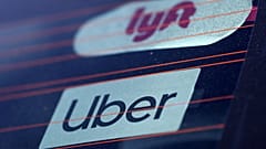 Uber and Lyft signs are seen on a car in Redondo Beach