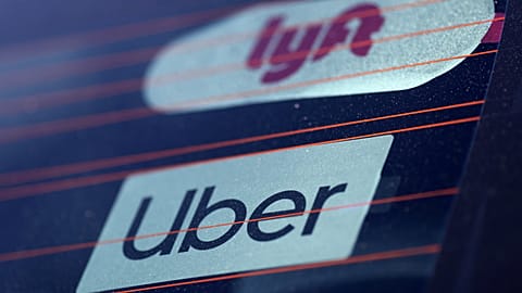 Uber and Lyft signs are seen on a car in Redondo Beach