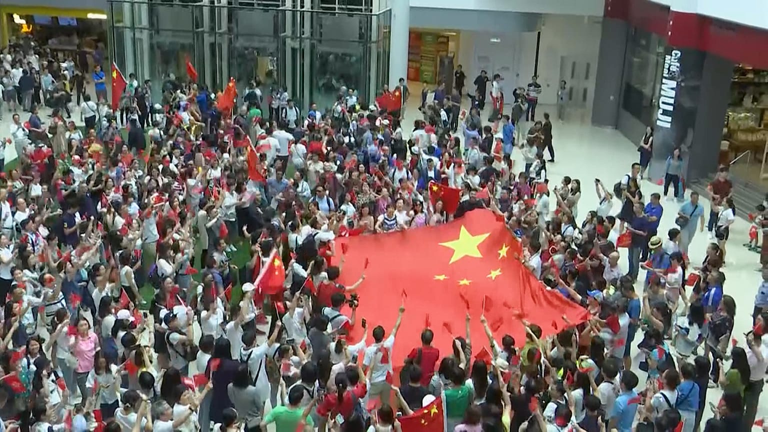 Counter protesters in Hong Kong wave Chinese flags 