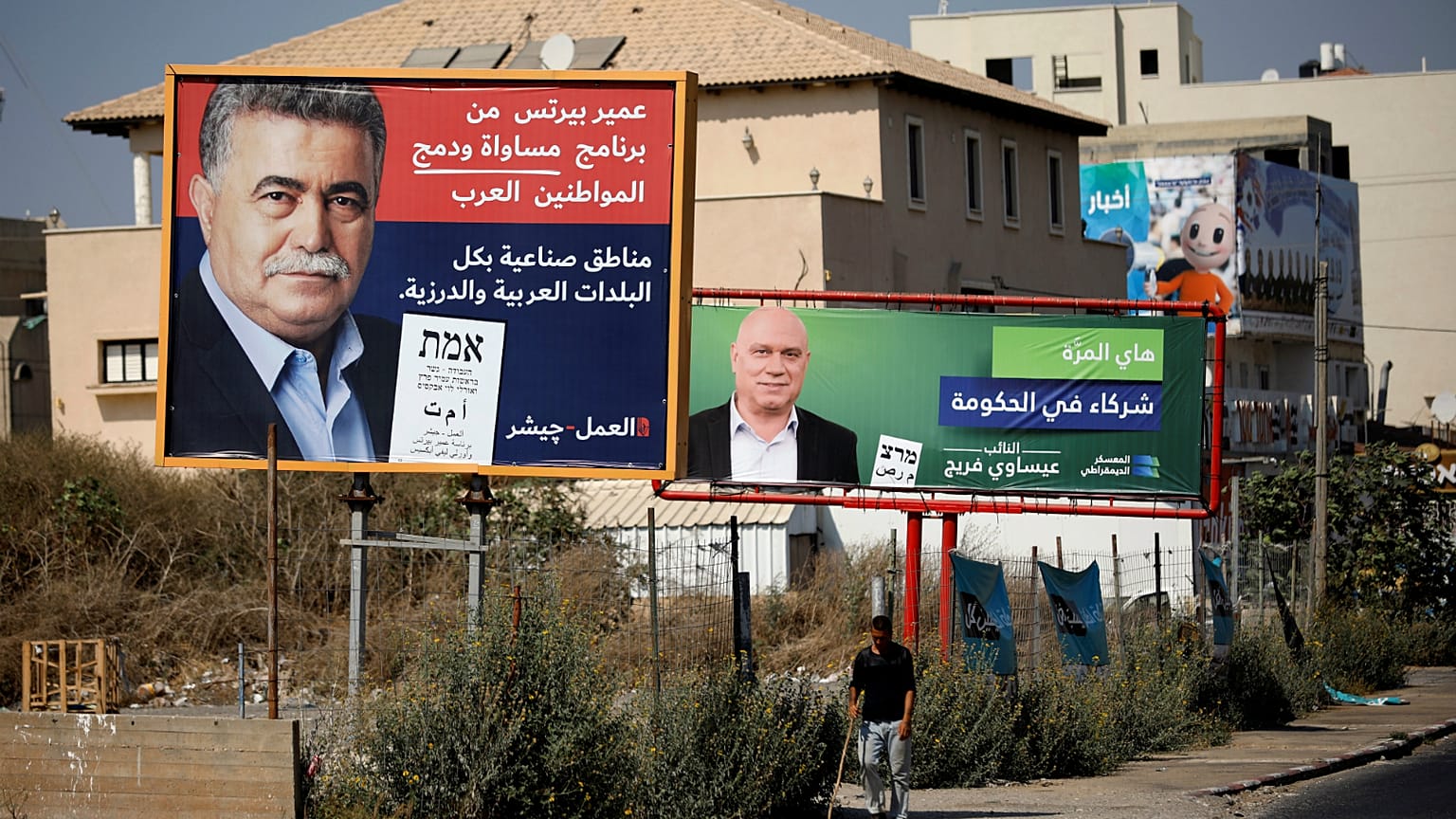 لافتة انتخابية لحزب العمال تصور زعيم الحزب عمير بيرتس بجانب لافتة أخرى للانتخابات الكنيست في إسرائيل