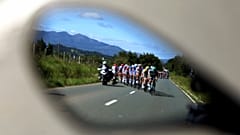 A Vuelta spanyol körverseny mezőnye egy autó visszapillantó tükrében