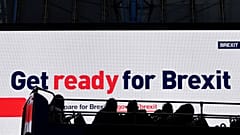 A bus passes an electronic billboard displaying a British government Brexit information awareness campaign advertisement in London, Britain