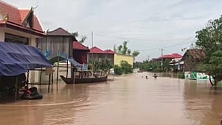 Камбоджийцы покидают дома на лодках 