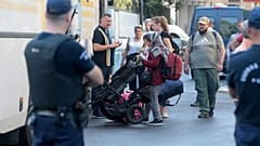Αστυνομικοί οδηγούν αλλοδαπούς σε λεωφορεία κατά τη διάκεια εκκένωσης κτιρίων, όπου τελούσαν υπό κατάληψη, από το 2016