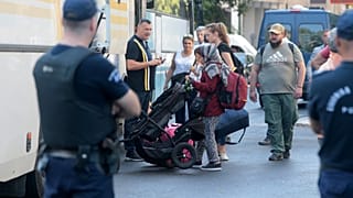 Αστυνομικοί οδηγούν αλλοδαπούς σε λεωφορεία κατά τη διάκεια εκκένωσης κτιρίων, όπου τελούσαν υπό κατάληψη, από το 2016