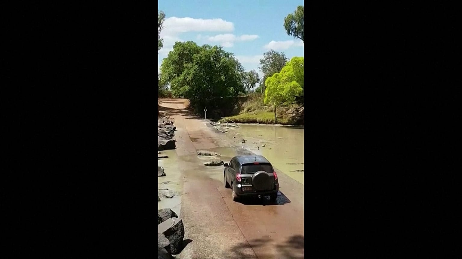 Vehicle stopped in its tracks by crocodiles lying in the road