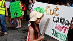 Corten el CO2, no los árboles, dice el cartel de esta niña en Tailandia