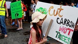 Corten el CO2, no los árboles, dice el cartel de esta niña en Tailandia