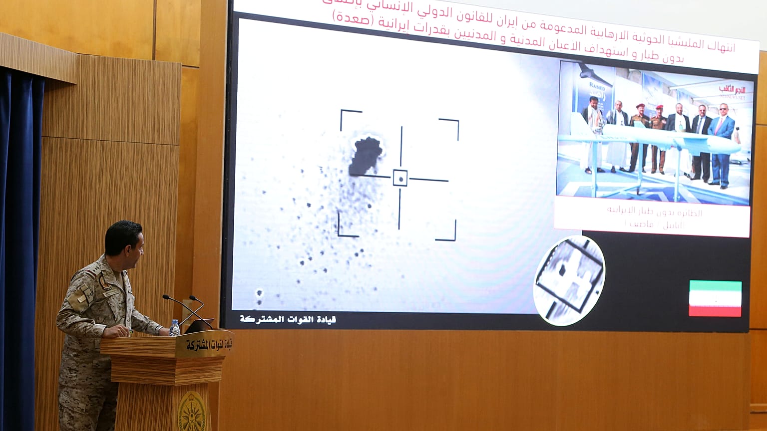 الناطق الرسمي باسم التحالف الذي تقوده السعودية في اليمن، العقيد تركي المالك، يعرض على الشاشة صورة قمر صناعي تظهر غارة بطائرة بدون طيار خلال مؤتمر صحفي بالرياض