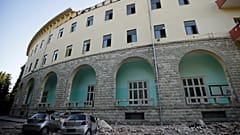 Destroyed cars stand next to a damaged building after an earthquake in Tirana, Albania, September 21, 2019.