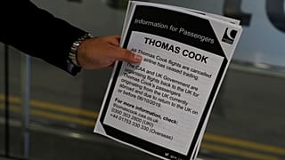 A man holds information on Thomas Cook flights at Manchester Airport, Manchester, Britain September 23, 2019.