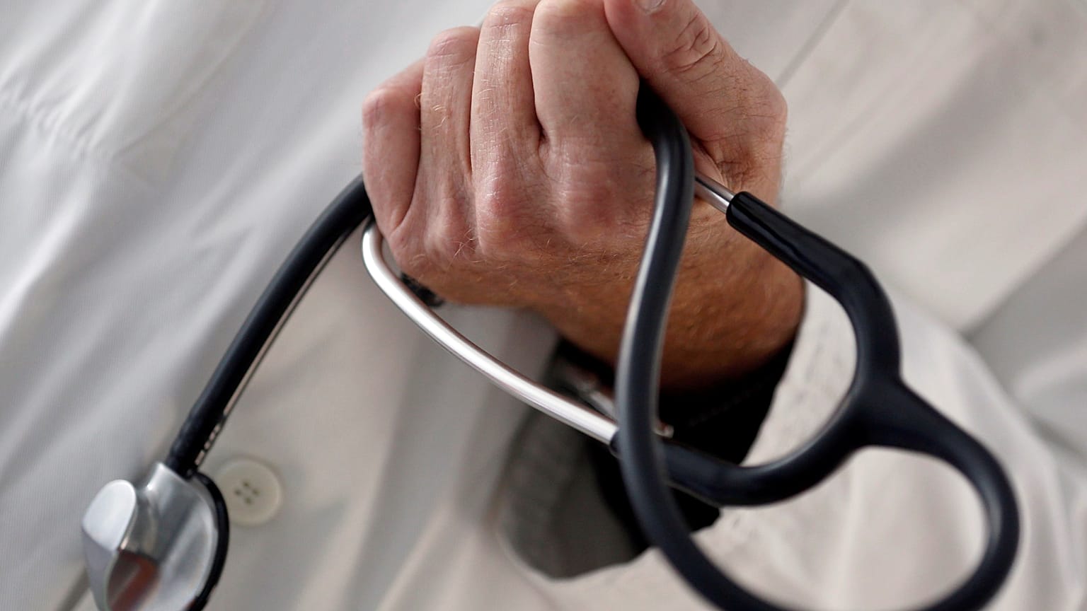 FILE PHOTO: A photo illustration shows a French general practitioner holding a stethoscope in a doctor's office in Bordeaux