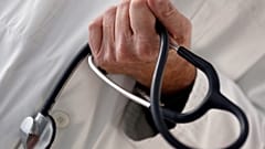 FILE PHOTO: A photo illustration shows a French general practitioner holding a stethoscope in a doctor's office in Bordeaux