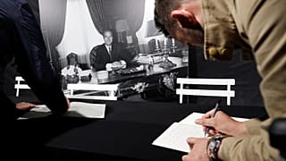 A man signs the book of condolences in front of Paris city hall to pay tribute to late former French President Jacques Chirac in Paris, France, September 26, 2019.