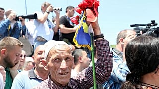 Ein Mann mit Flaggen von Albanien und dem Kosovo nimmt am 20. Jahrestag des Einsatzes von NATO-Truppen im Kosovo in Pristina teil, Kosovo 12. Juni 2019.
