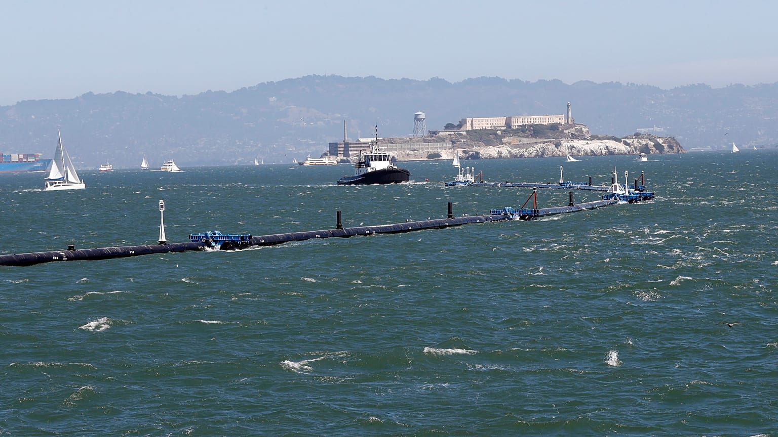 Az Ocean Cleanup nevű szerkezetet vontatja ki a projekt hajója a San Franciscó-i öbölből 2018. szeptember 9-én.