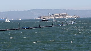 Az Ocean Cleanup nevű szerkezetet vontatja ki a projekt hajója a San Franciscó-i öbölből 2018. szeptember 9-én.
