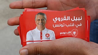 مواطن يحمل صور دعائية للمرشح الرئاسي التونسي نبيل القروي