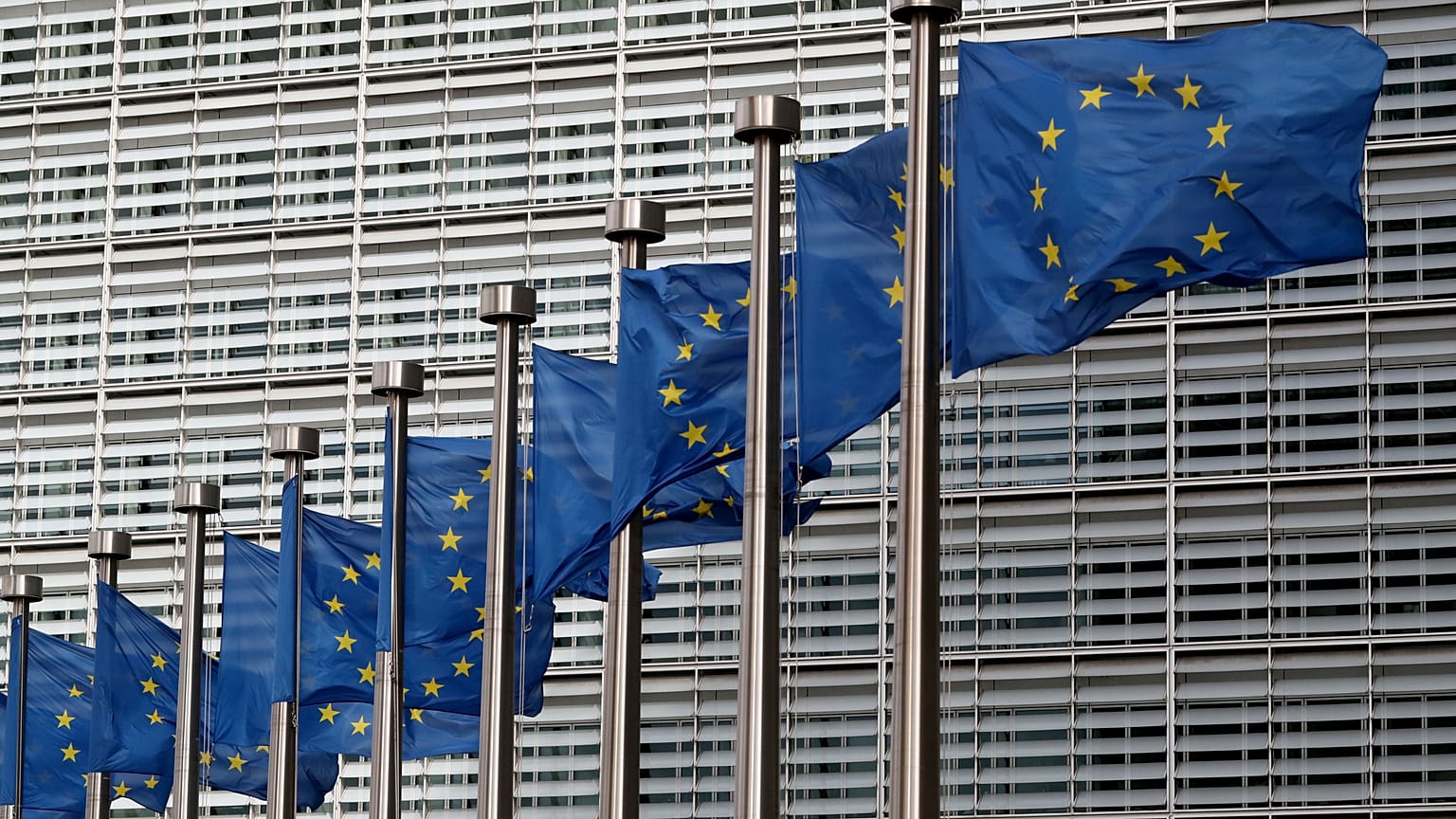 EU flags flutter in front of the European Commission headquarters in Brussels