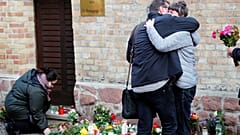 People lay flowers as they mourn outside the synagogue in Halle