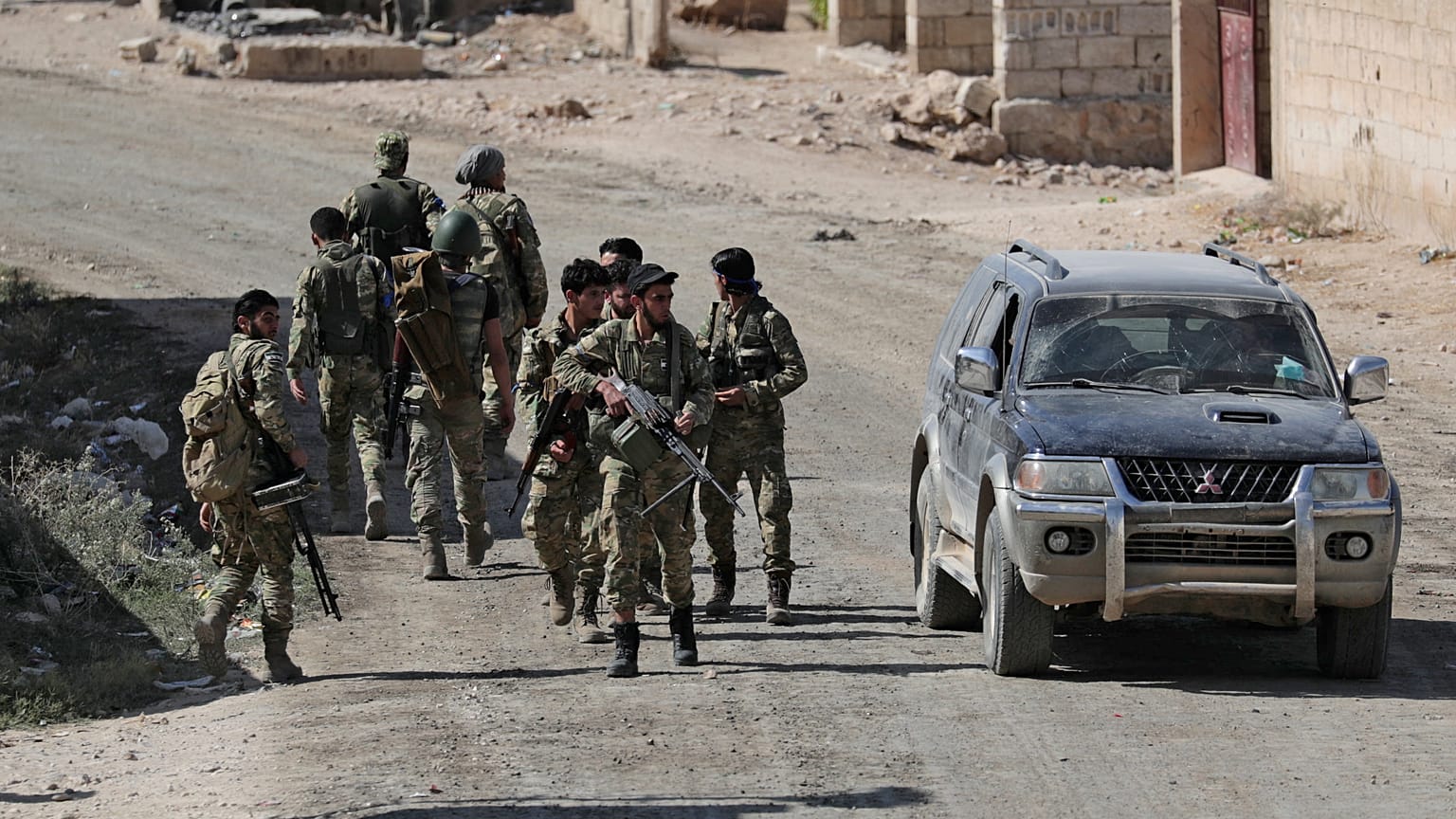 Turkey-backed Syrian rebel fighters walk together near the border town of Tel Abyad, Syria, October 12, 2019.