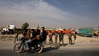 People ride on a motorbike in the city of Manbij, Syria October 15, 2019. 