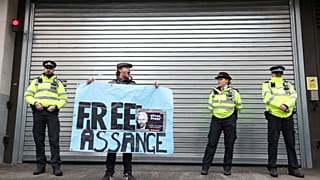 A demonstrator holds a banner during a protest outside a London court, Britain, October 21, 2019.