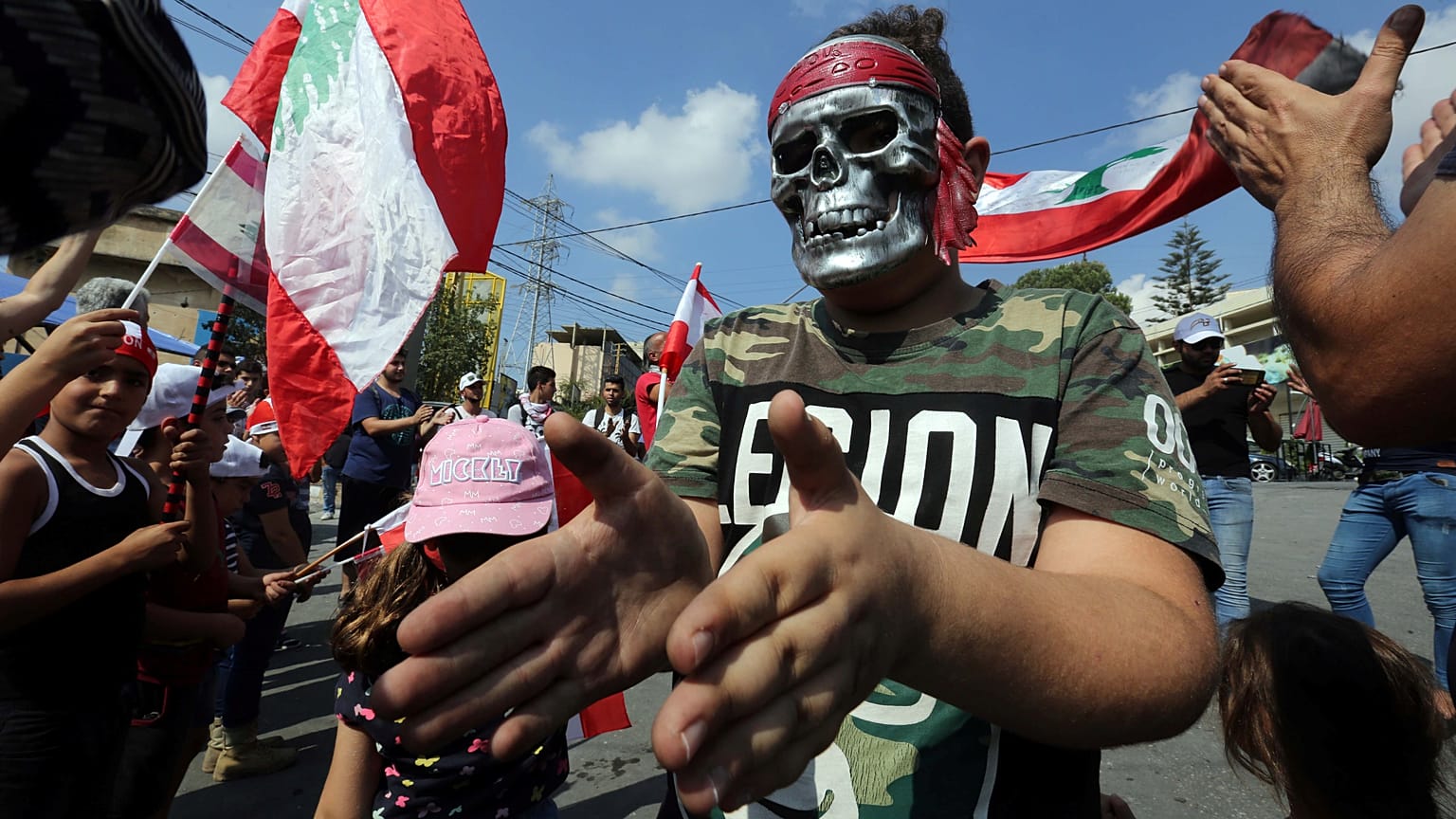 A demonstrator wearing a mask takes part in an anti-government protest in the southern city of Nabatiyeh, Lebanon October 21, 2019.