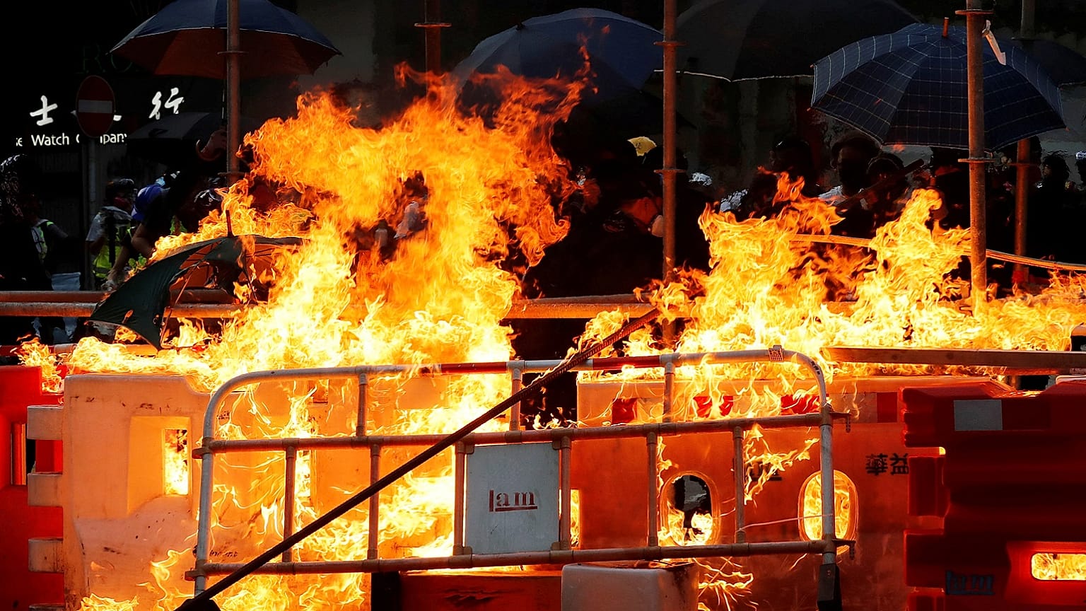 Protesters set fire on a barricade as policemen advance toward them during an anti-government protest protest in Hong Kong, China, October 20, 2019