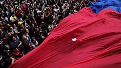 Demonstrators march with a giant flag during a protest against Chile's state economic model in Santiago, Chile October 25, 2019. 