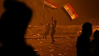 متظاهران يرفعان علم العراق خلال احتجاجات وسط بغداد - 2019/10/26