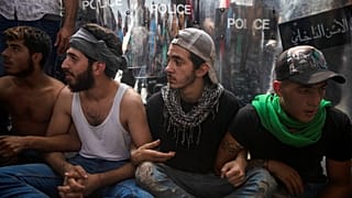 محتجون يجلسون أمام طوق امني وسط بيروت، إثر محاولة الشرطة فتح طريق قطعها المتظاهرون - 2019/10/25